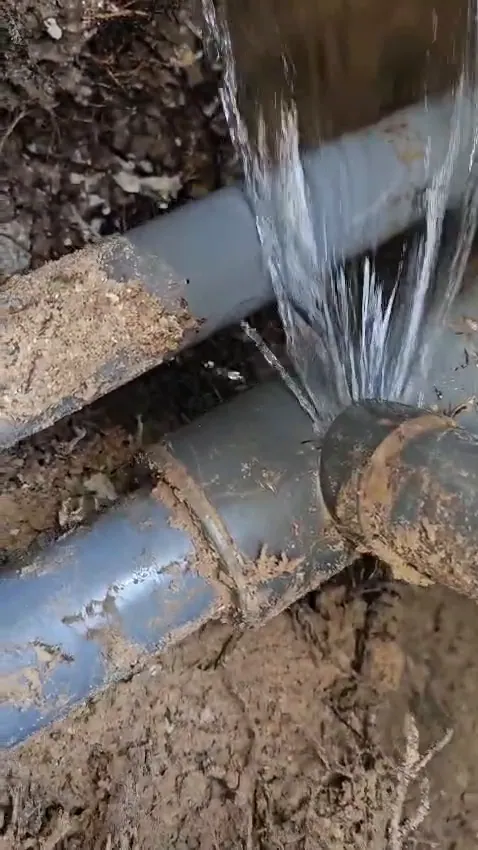 The broken joint, spraying water under the deck.